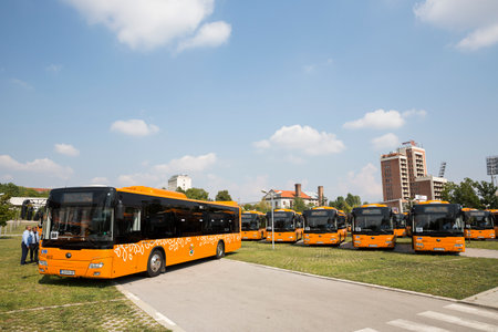 Sofia, Bulgaria - August 31, 2016: New modern busses for public transportation are shown in a row in a parking lot. Bus drivers are standing before them.のeditorial素材