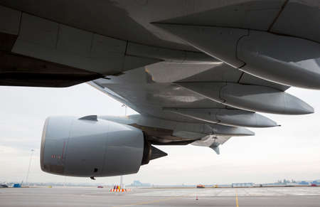 Airplane's engine and wing on a runway at an airport.の写真素材