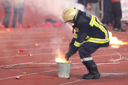 Sofia, Bulgaria - October 15, 2016: Firefighter is putting down football fans' fire from torches during a match between Bulgaria's CSKA and Levski.のeditorial素材