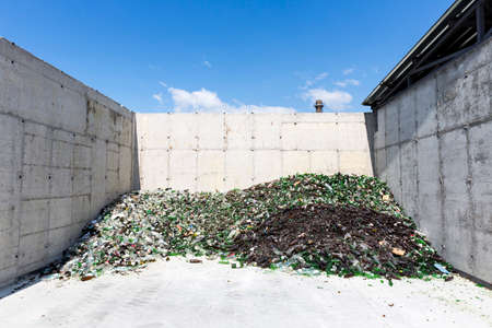 Glass waste for recycling in a recycling facility. Different glass packaging bottle waste. Glass waste management. Process of waste glass into usable products. Pile of different bottles.の写真素材