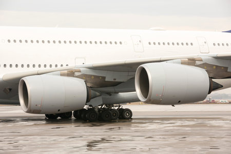 Airbus A380 airplane's engines on a wing on a runway at an airport.