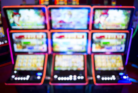 Blurry image of slots machines and other gambling equipment at a casino. Out of focus (bokeh) colourful and high contrast picture in a casino.の写真素材