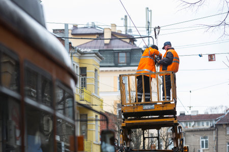 Sofia, Bulgaria - November 28, 2016: Workers in uniforms repair the electricity cables for the tram cars.のeditorial素材