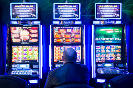 Sofia, Bulgaria - November 24, 2016: A a man plays on a slot machine in a casino equipment exhibition in Inter Expo Center.のeditorial素材