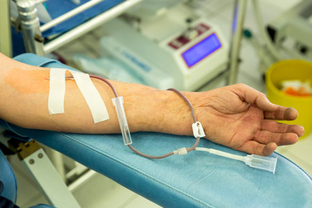 The hand of a blood donor during the process of donating blood in a hospital.の写真素材