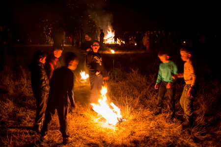 Lozen, Bulgaria - 26 February, 2017: Boys play fire near a bonfire during a fire ritual celebration...
