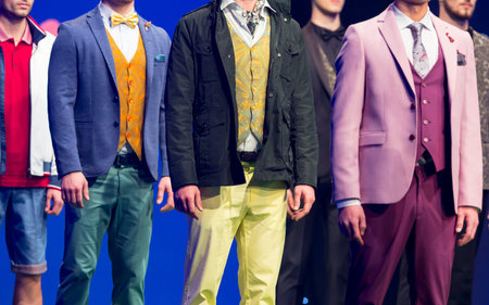 Male models walk the runway in different modern and colourful suits during a Fashion Show. Fashion...
