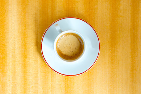 White coffee cup on a wooden table. Directly from above.の写真素材