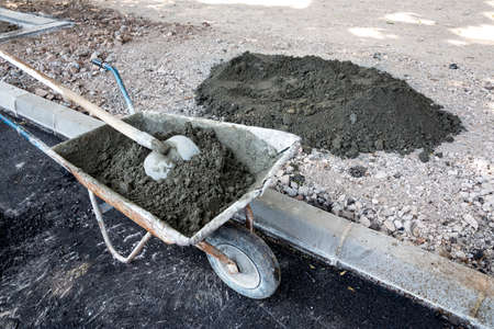 Construction cart full with asphalt and a shovel on a construction site on the street.の写真素材