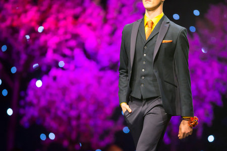 A male model walks the runway in stylish modern business during a Fashion Show. Fashion catwalk...