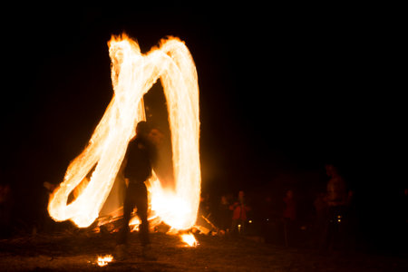 A boy spins rings of fire near a bonfire during a fire ritual celebration of Sirni Zagovezni held seven weeks before Easter. People beleive they chase away evil spirits with fire rituals. Village of Lozen, Bulgaria.のeditorial素材