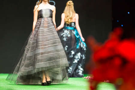 A female model walks the runway in beautiful grey dress during a Fashion Show. Fashion catwalk event showing new collection of clothes.の写真素材
