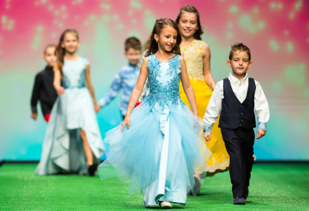 Sofia, Bulgaria - 21 March 2017: Children models walk the runway during the Sofia Fashion Show. Fashion catwalk event showing new collection of clothes. Girl in blue dress.のeditorial素材
