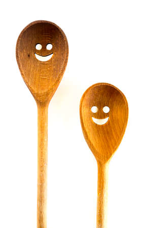 Wooden smiley face spoons on a white background. Studio shot. Set of kitchen utensil.の写真素材