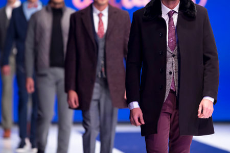 Male models walk the runway in stylish suits during a Fashion Show. Fashion catwalk event showing new collection of clothes. Single model.のeditorial素材