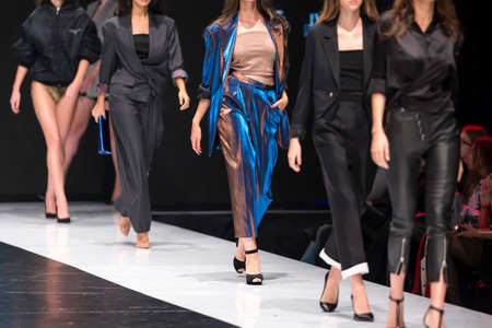 Female models walk the runway in different dresses during a Fashion Show. Fashion catwalk event showing new collection of clothes. In a row.の写真素材