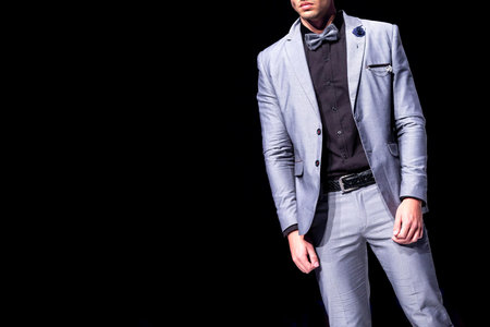 Male model walks the runway in silver suit during a Fashion Show. Fashion catwalk event showing new...
