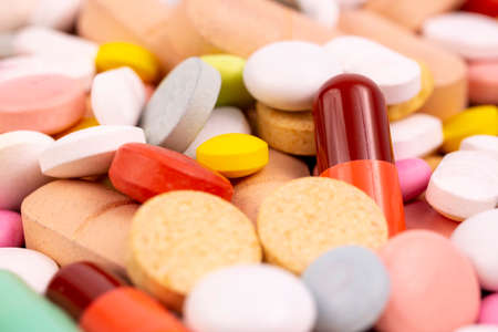 Different colorful pills and capsules. Global pharmaceutical industry for billions dollars per year. Pharmaceutical drugs for use as medications. Studio shot from above. Macro.の写真素材