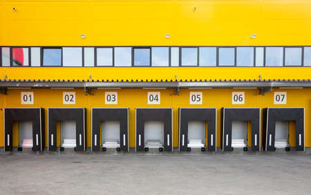 Seven truck loading docks at a distribution warehouse. Distribution hub for sorting packages and parcels.の写真素材