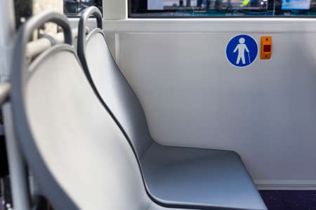 Red button STOP on the bus. Elderly (Old) People Symbol. Bus seats. New modern busses.の写真素材