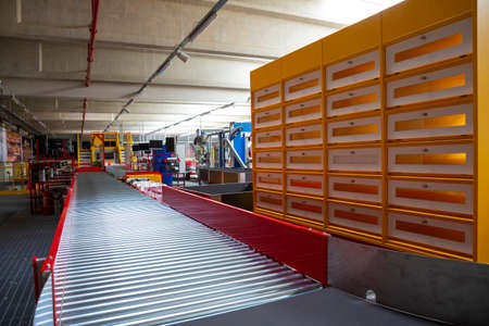 Empty conveyor sorting belt at distribution warehouse. Distribution hub for sorting packages and parcels delivered by air transportation.の写真素材