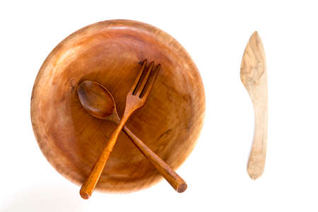 Wooden bowl with spoon, knife and fork on a white background. Studio shot. Set of kitchen utensil.の写真素材