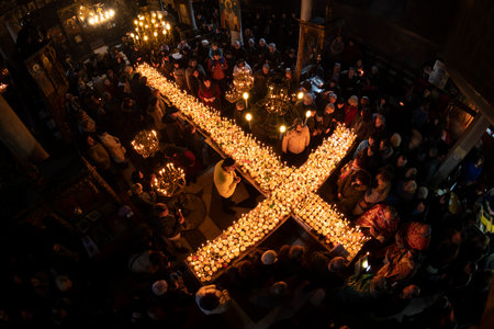 Blagoevgrad, Bulgaria - February 10, 2019: Worshippers light candles on jars with honey during a religious ritual marking the day of Saint Haralampi - the Orthodox patron saint of beekeepers - in the church of the Presentation of the Blessed Virgin.のeditorial素材