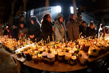 Blagoevgrad, Bulgaria - February 10, 2019: Worshippers light candles on jars with honey during a...