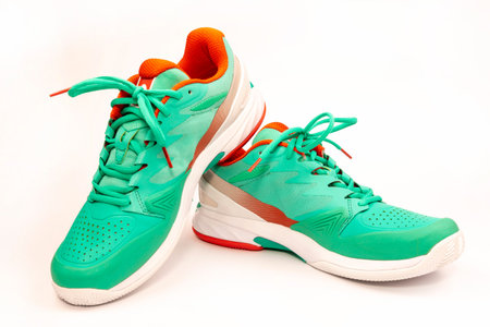 Red, cyan, white pair of new tennis shoes in studio shot over white background.