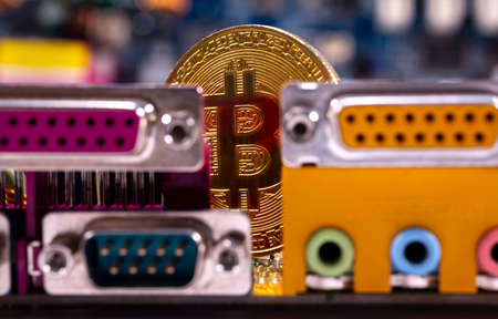 Virtual cryptocurrency money Bitcoin golden coin on a computer printed circuit board PCB. The future of money. Computational equipment.の写真素材