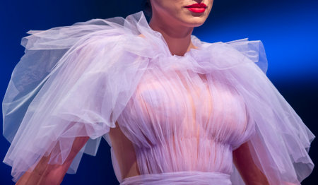 Female model walks the runway in a beautiful pink dress during a Fashion Show. Fashion catwalk event showing new collection of clothes. Unrecognizable person. Red lips.のeditorial素材