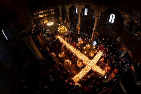 Blagoevgrad, Bulgaria - February 10, 2019: Worshippers light candles on jars with honey during a religious ritual marking the day of Saint Haralampi - the Orthodox patron saint of beekeepers - in the church of the Presentation of the Blessed Virgin.のeditorial素材