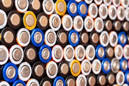 Multiple used AA alkaline batteries are seen arranged in a pile. Closeup side view from the minus side of the battery.の写真素材