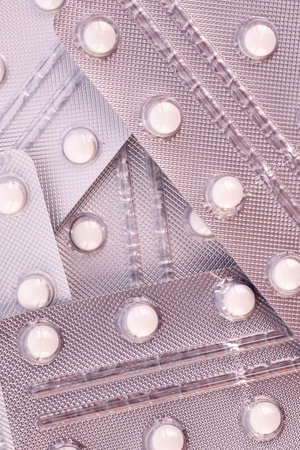 White pills in silver plastic packs - blisters. Global pharmaceutical industry for billions dollars...