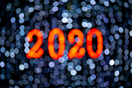 Slightly out of focus (defocused) 2020 new year lights. Orange 2020 on a cold bluish background.の写真素材