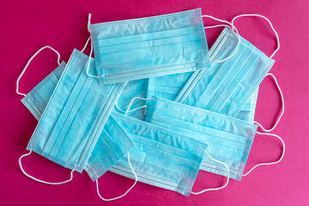 Blue surgical protective masks on a purple background. Coronavirus (COVID-19) hysteria is leading to mass mask shortages in the beginning of 2020.の写真素材