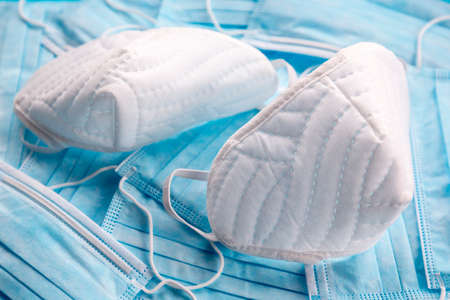 White protective masks on blue surgical masks. Coronavirus (COVID-19) hysteria is leading to mass mask shortages in the beginning of 2020.の写真素材
