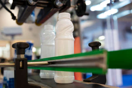 White milk bottles on a production line in a dairy farm.の写真素材