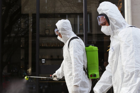 Sofia, Bulgaria - 11 April, 2020: Workers spray disinfectant outside on a street against the spread of coronavirus disease COVID-19.のeditorial素材