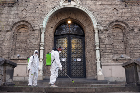 Sofia, Bulgaria - 11 April, 2020: Workers spray disinfectant outside of Sveta Nedelya Church against the spread of coronavirus disease COVID-19.のeditorial素材