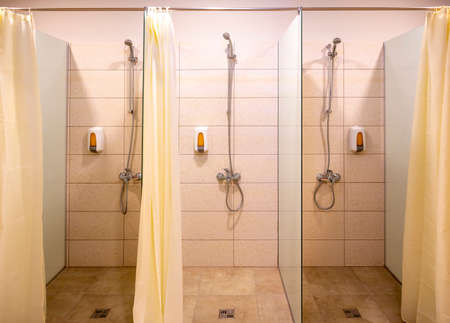 Three new showers with curtains and soap dispensers.の写真素材
