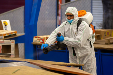 Sofia, Bulgaria - 7 April, 2020: Worker sprays disinfectant outside of ? food market against the spread of coronavirus disease COVID-19.のeditorial素材