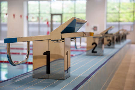 Indoor swimming pool full of water with trampolines on the side.の写真素材