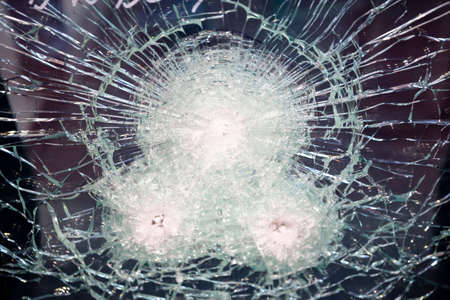 Cracked bulletproof glass is seen witrh bullets inside.の写真素材