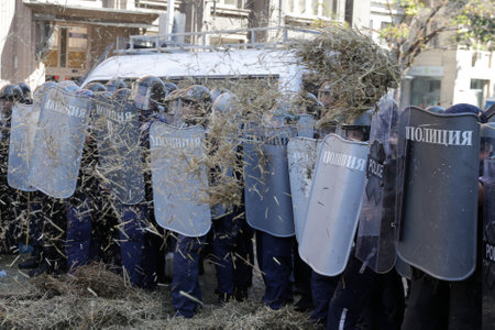 Sofia, Bulgaria - 2 September, 2020: Police officers in protective uniforms from the gendarmery hide behind their shields during an anti-government protest.のeditorial素材