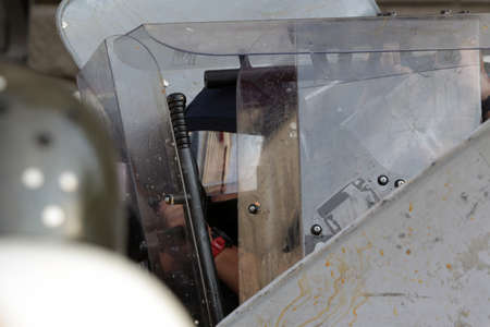 Police officers in protective uniforms from the gendarmery hide behind their shields during an anti-government protest.の写真素材