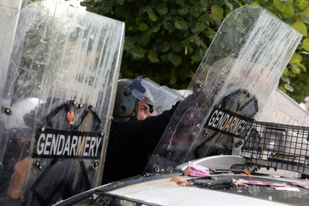 Sofia, Bulgaria - 2 September, 2020: Police officers in protective uniforms from the gendarmery hide behind their shields during an anti-government protest.のeditorial素材