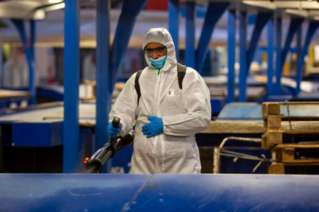 Sofia, Bulgaria - 7 April, 2020: Worker sprays disinfectant outside of ? food market against the spread of coronavirus disease COVID-19.のeditorial素材