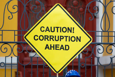 "Caution! Corruption ahead" yellow sign is held by an anti-government protester in Sofia, Bulgaria.の写真素材