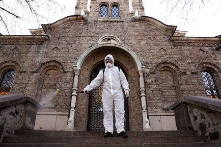 Sofia, Bulgaria - 11 April, 2020: Worker sprays disinfectant outside of Sveta Nedelya Church against the spread of coronavirus disease COVID-19.のeditorial素材